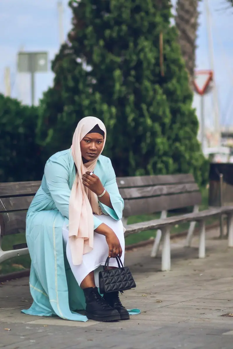 Gamis biru muda dengan scarf peach di tepi pelabuhan